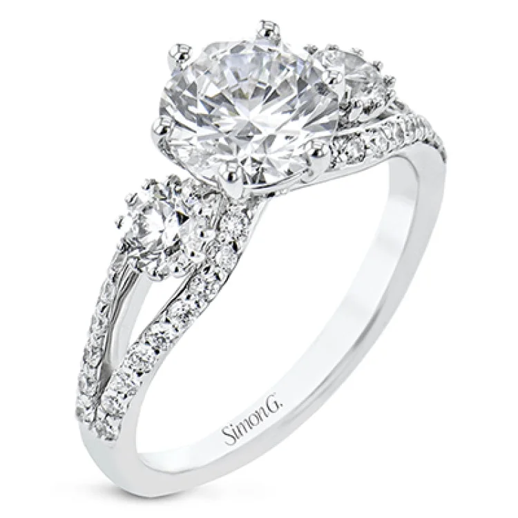 Women’s heart-shaped engagement rings-This 3 stone engagement ring has a split shank design and 2 side diamonds 1/4 ct each, totaling 0.48 ctw. and outlined with diamond accents of .35 ctw.